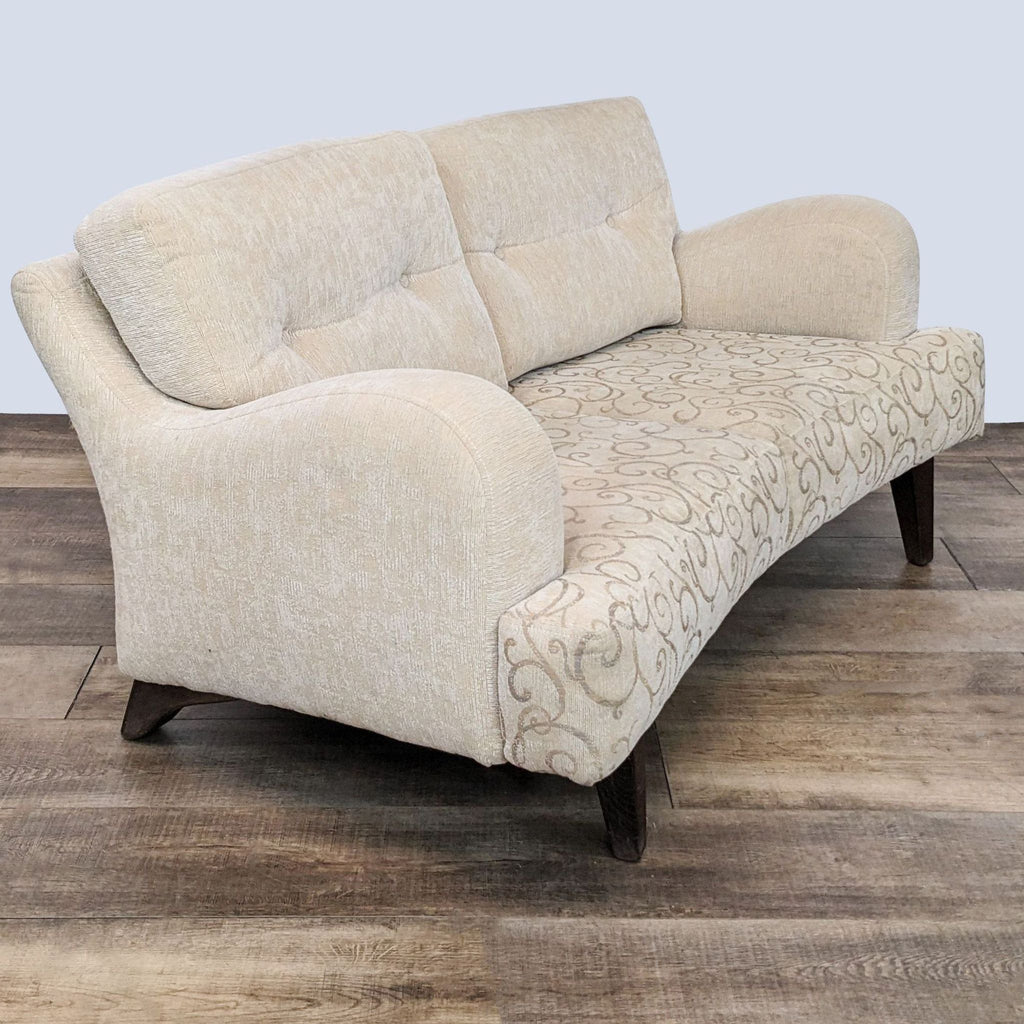 Beige upholstered Reperch loveseat with scroll pattern seat and saddle arms, angled view.