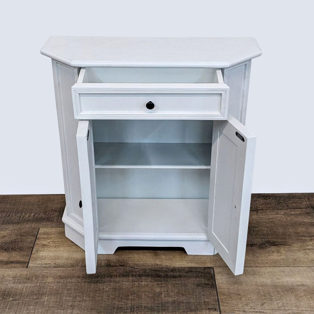 2. Open view of Ballard Designs Piccola end table revealing an adjustable shelf inside, with drawer and cabinet door ajar on a wooden floor.