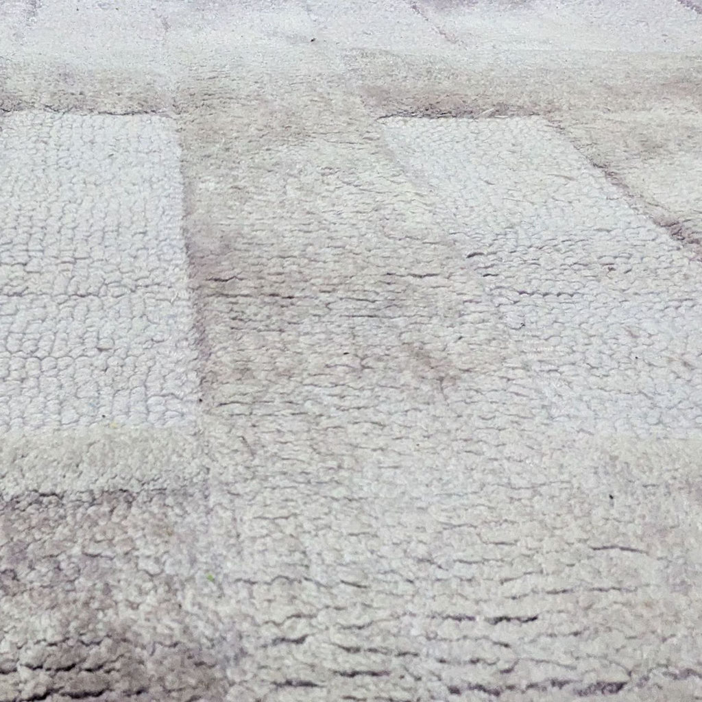 Alt text 2: Close-up of the Bella tufted area rug by Anthropologie, showing the texture and lilac color of the fabric.
