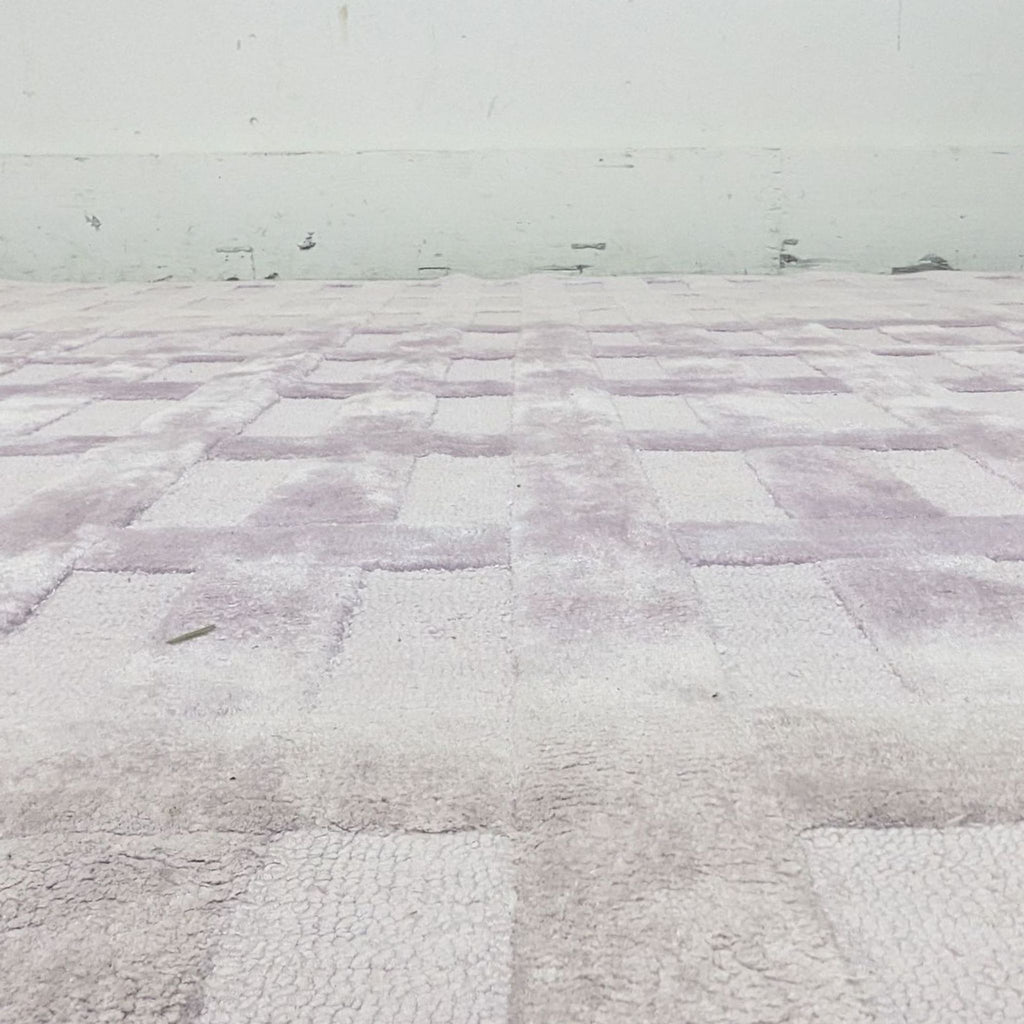 Alt text 3: Anthropologie's Bella 8'x10' rug in lilac, captured in a room setting, emphasizing the tufted squares pattern.