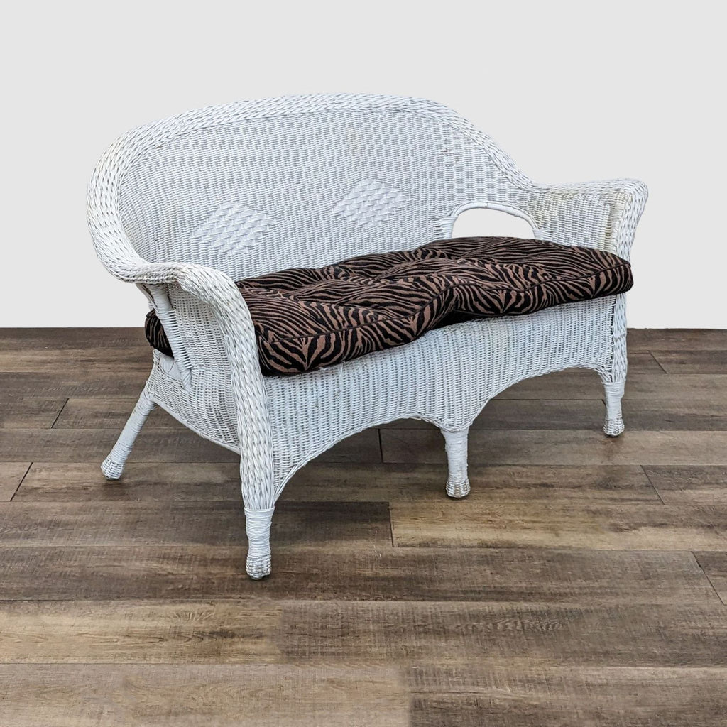 2. Elegant Reperch white wicker loveseat featuring exotic tiger stripe cushions, shown in a room with wooden flooring.