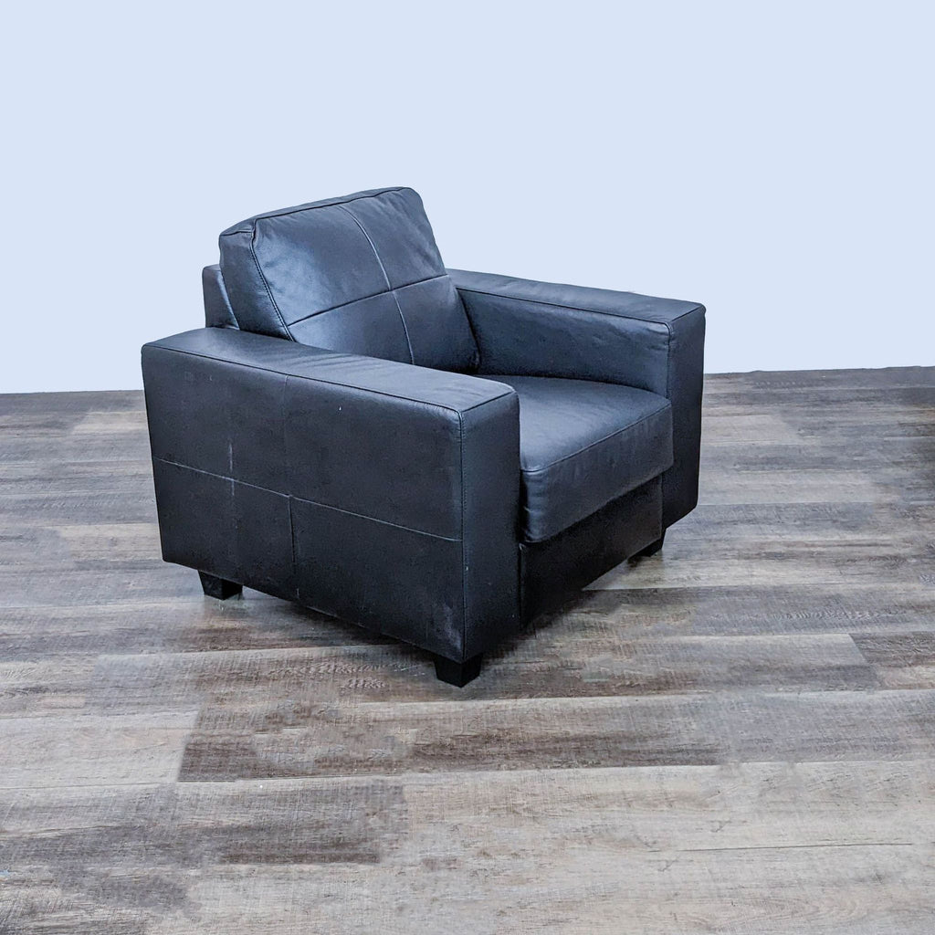 Angled view of a black IKEA Skogaby club chair showcasing its block arms and wood block feet.