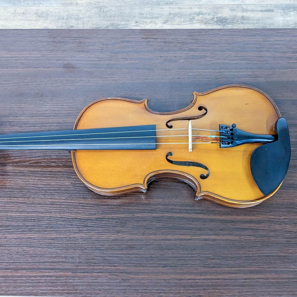 2. Top view of a Reperch violin showcasing its classic design and warm finish on a wooden surface, with no case or bow visible.