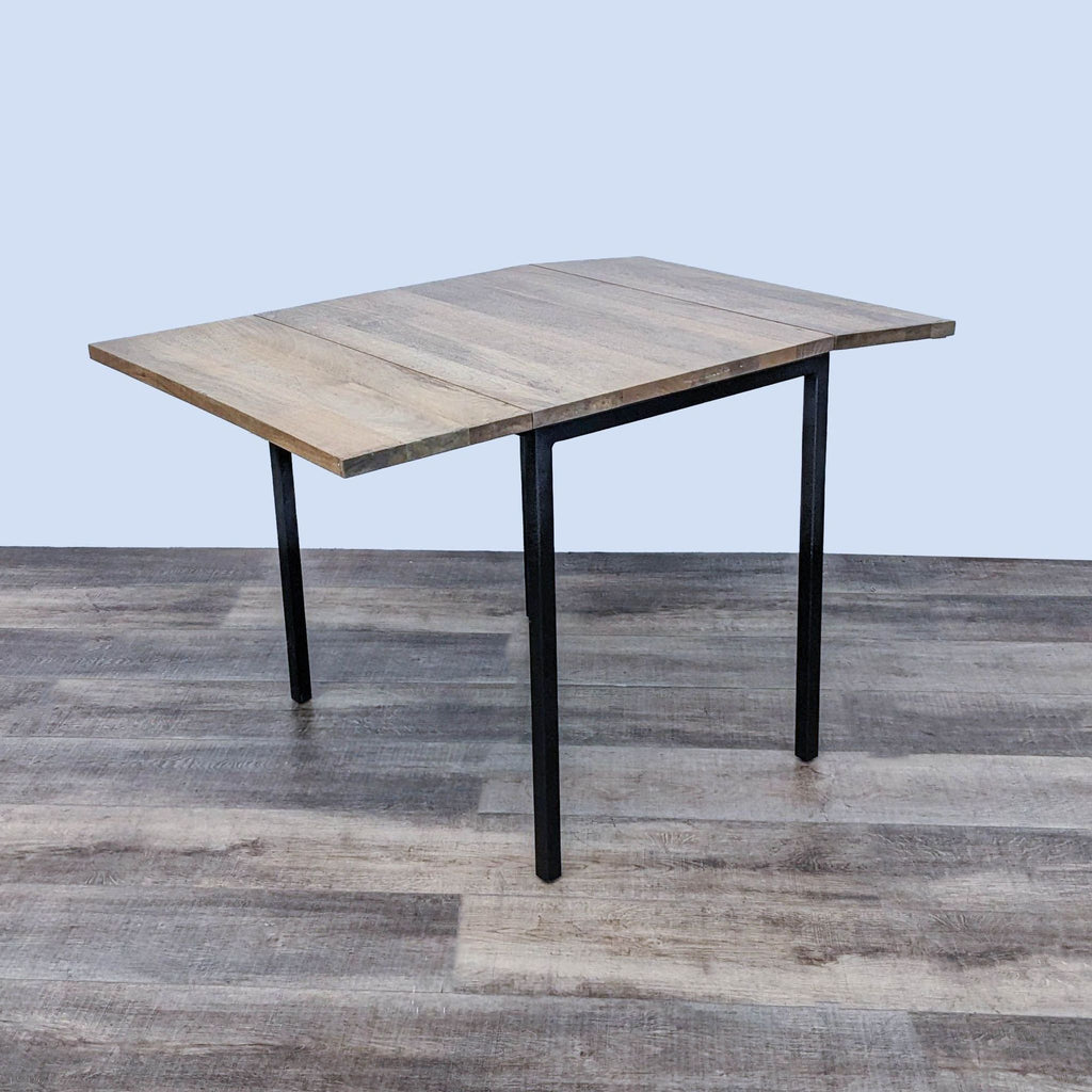Drop leaf side of West Elm Box Frame Dining Table extended for more space.