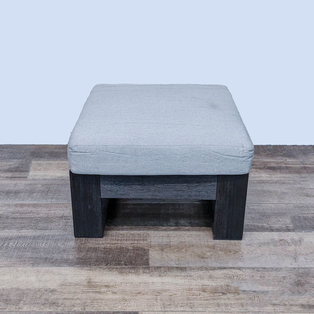 28" West Elm ottoman featuring a gray cushion atop a wire brushed wood base in a room setting.