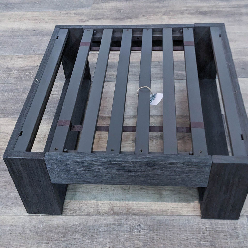 Inverted view of a 28" West Elm square ottoman showcasing the wooden slat construction without cushion.