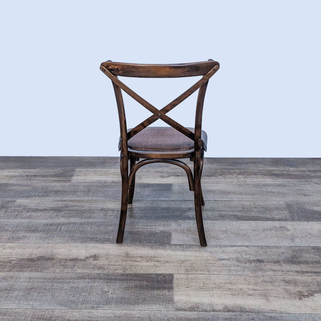 Rear view of a Scandinavian Design X back dining chair with bentwood construction and upholstered seat on wood flooring.
