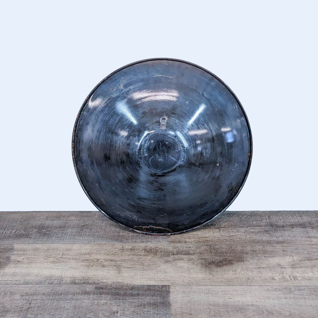 a large black glass vase on a wooden table.