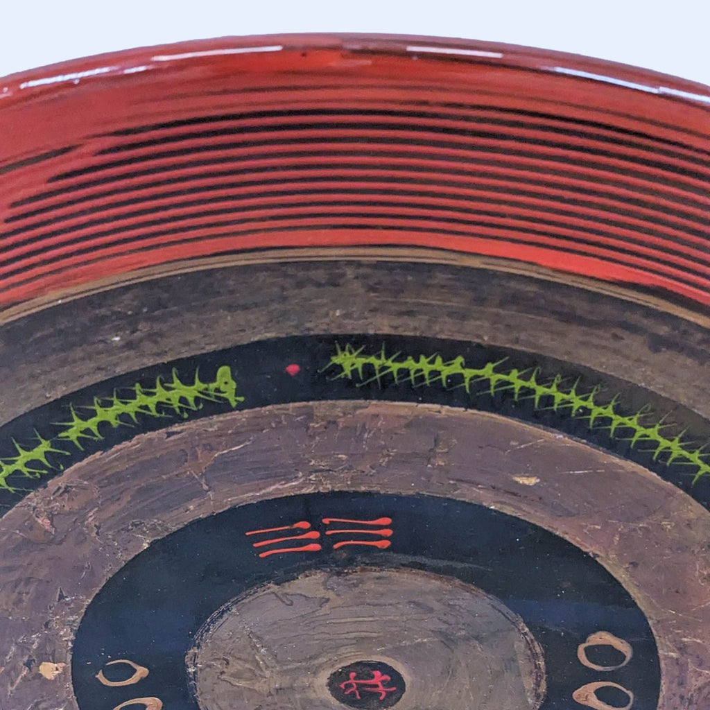 2. Close-up of Reperch handcrafted plate showing detailed green and red traditional motifs on art piece.
