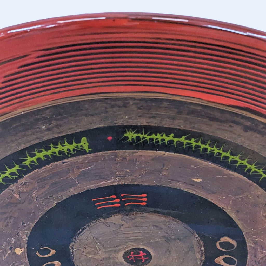 a large indian pottery bowl with a red and black painted design.