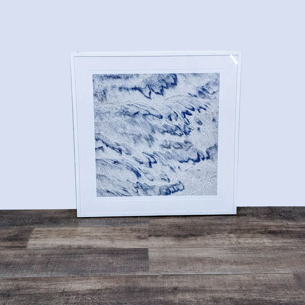 1. "Abstract sand art with blue and gray patterns, framed in white under plexiglass by Reperch, displayed against a grey backdrop."