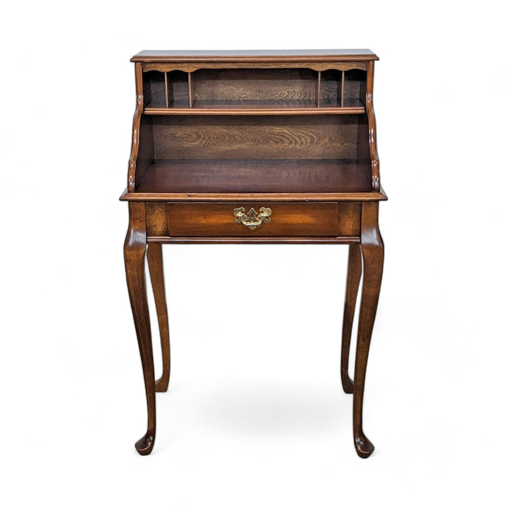 Front view of vintage Ethan Allen wooden desk with ornate legs.