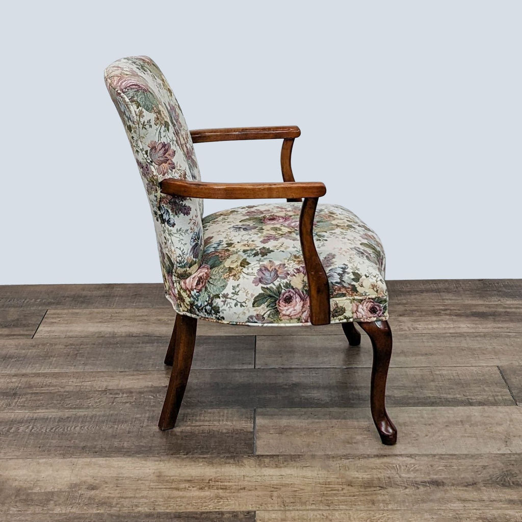 3. Side view of a floral upholstered Ethan Allen accent chair with armrests and curvy wooden legs.