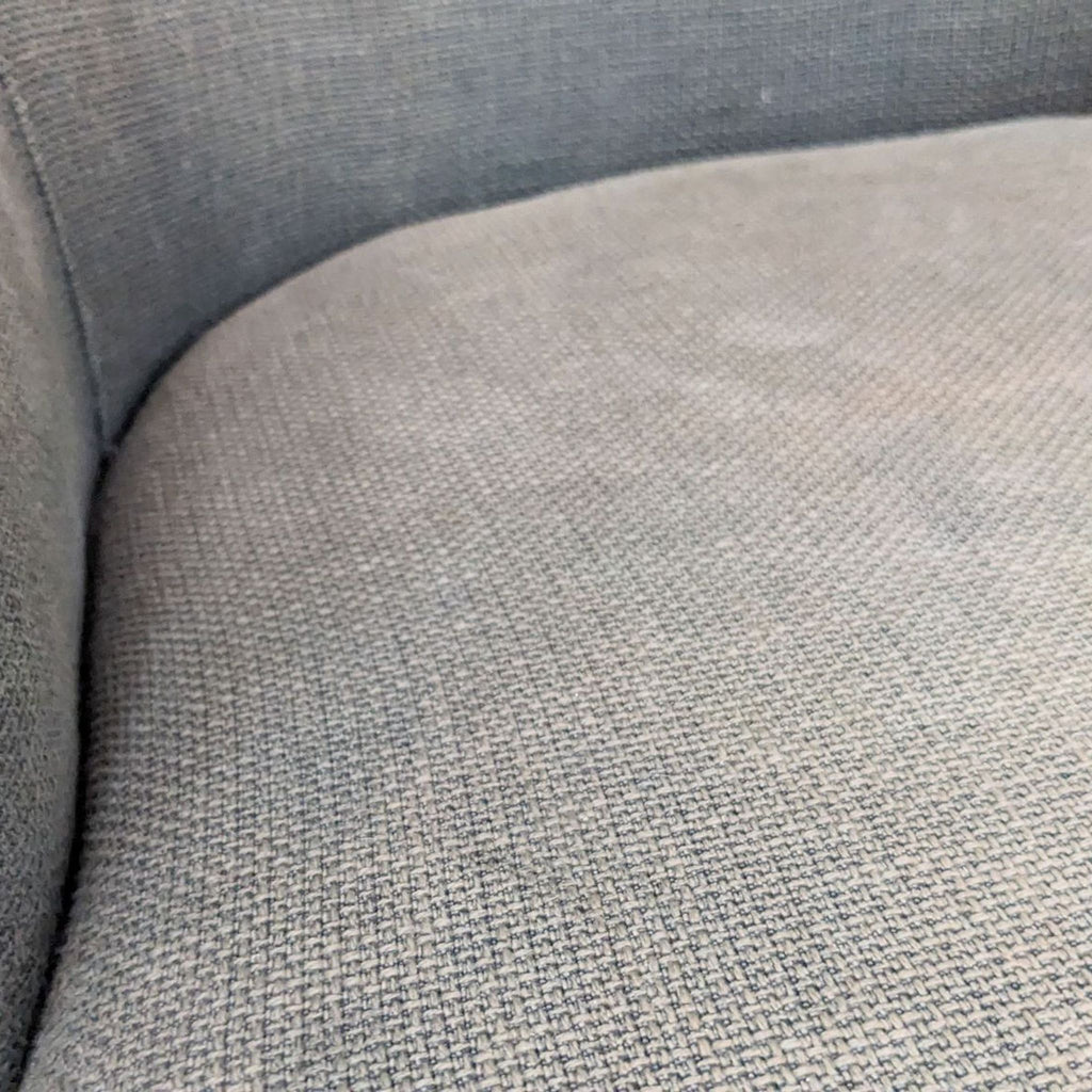3. Close-up of the grey fabric upholstery on a padded seat cushion of West Elm's Wayne stool.