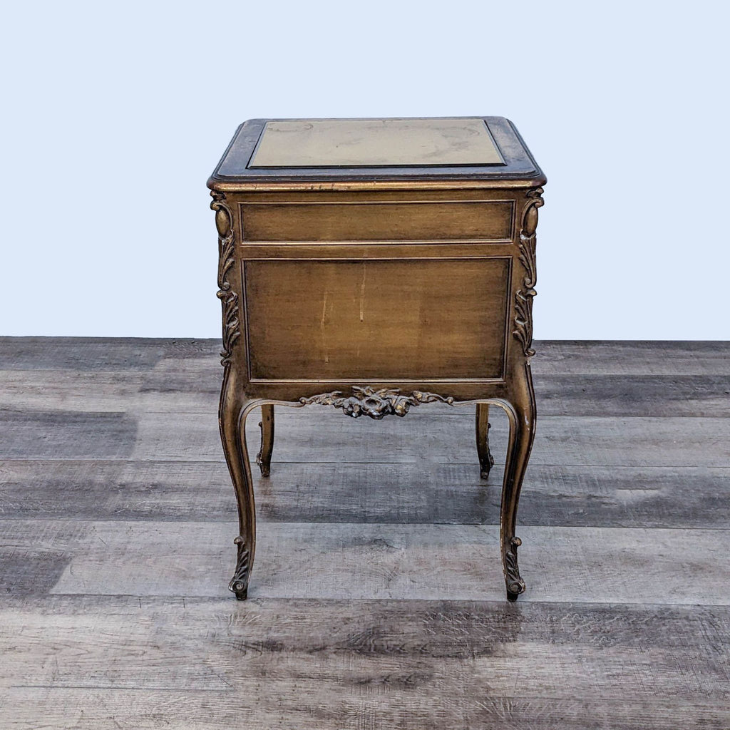 Carved Reperch end table with closed drawer, decorative floral detailing, cabinet storage, and mirrored gold top.