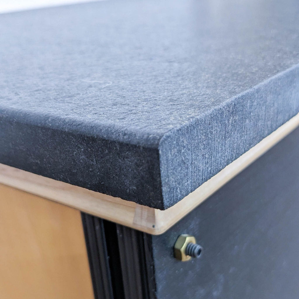 Close-up of a Reperch entertainment center's stone top detailing, showcasing the texture and edge finishing.