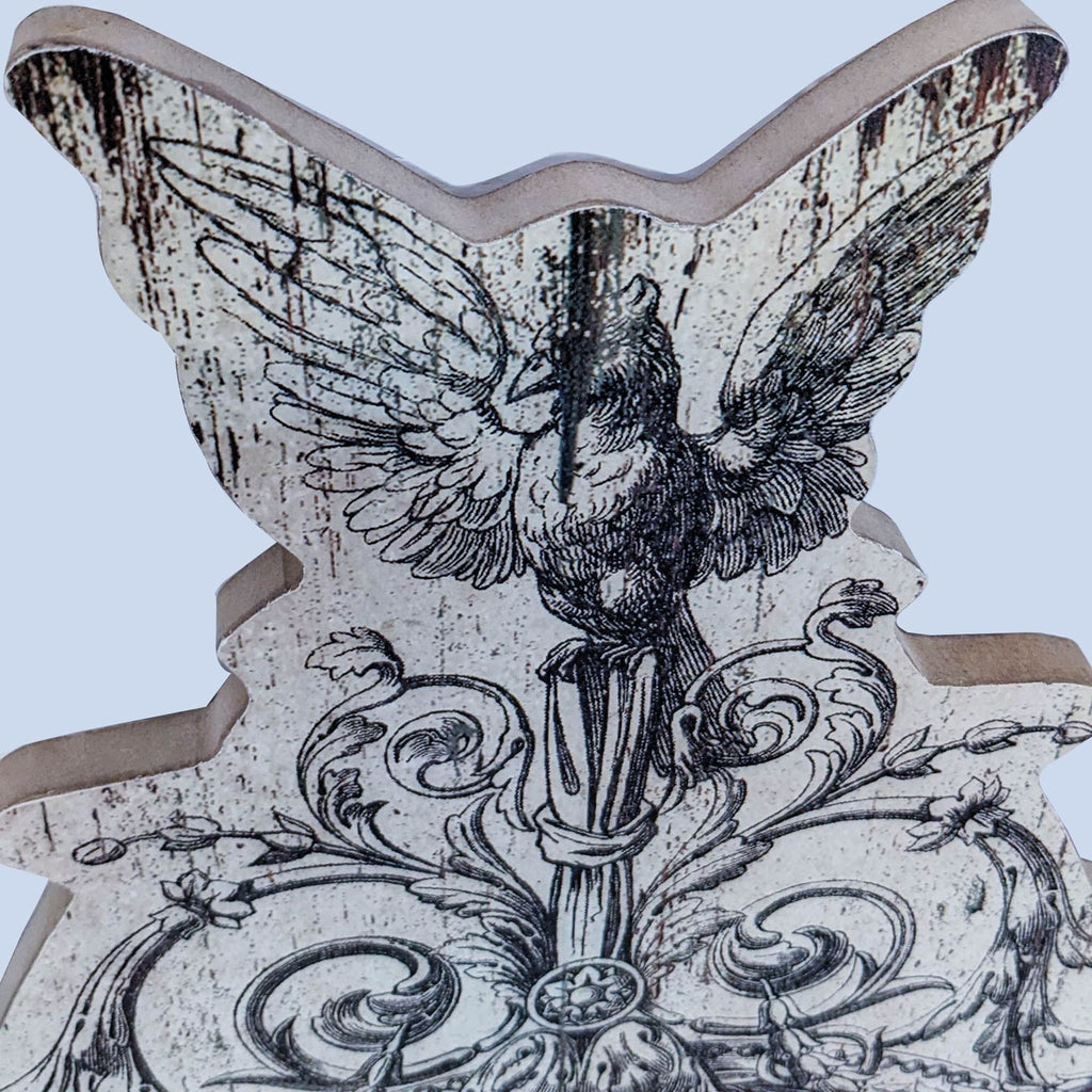 Close-up of decorative bird detail on the artistic mirror frame.