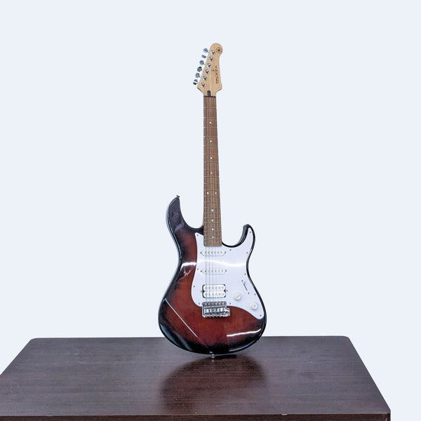 Yamaha electric guitar with sunburst finish, maple neck, and rosewood fretboard on a table.