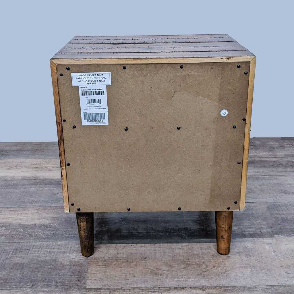 Back view of mid-century style nightstand showing wooden frame and tapered legs.