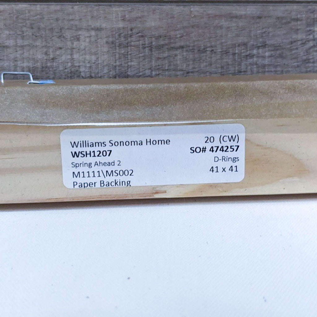 3. "Detailed view of the back of a framed canvas showing a Williams Sonoma Home label with the artwork's title and size specifications."