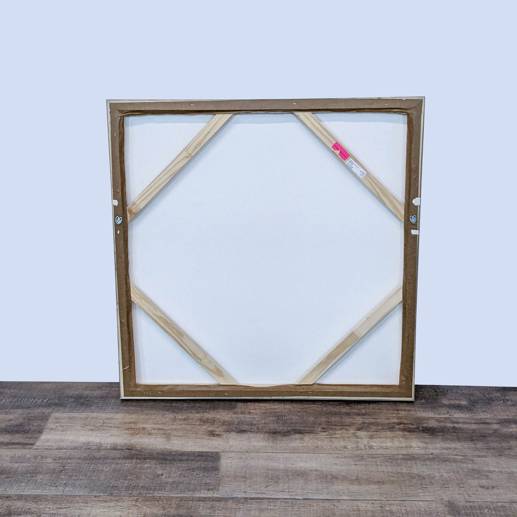 - "Rear view of a framed giclee canvas artwork showcasing a wooden stretcher and a wire for hanging."