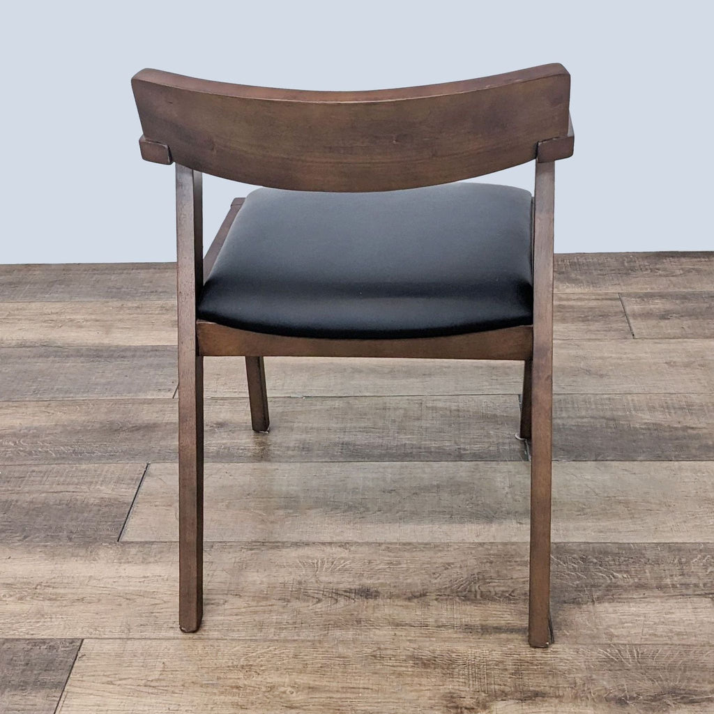 Article Zola wooden chair with a dark finish, showcasing the curved backrest and leather seat on wood flooring.