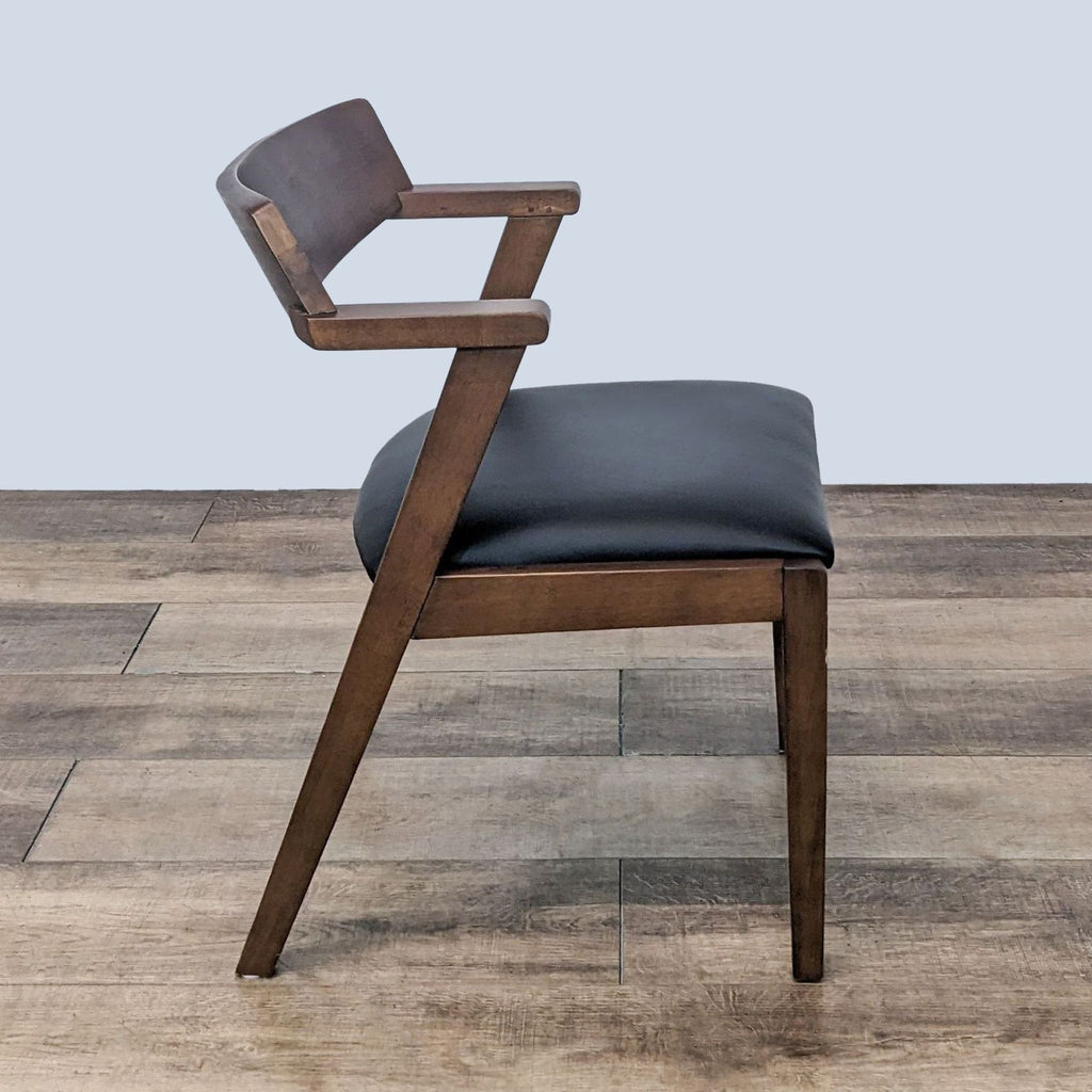 Side angle view of the Zola dining chair by Article, highlighting the sleek wooden frame and leather cushion.