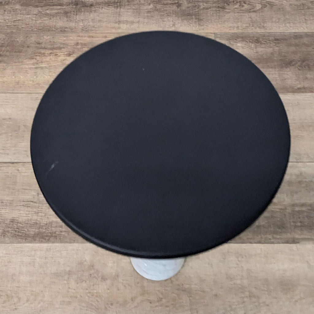 Black-metal Narro side table with a marble base, viewed from above.