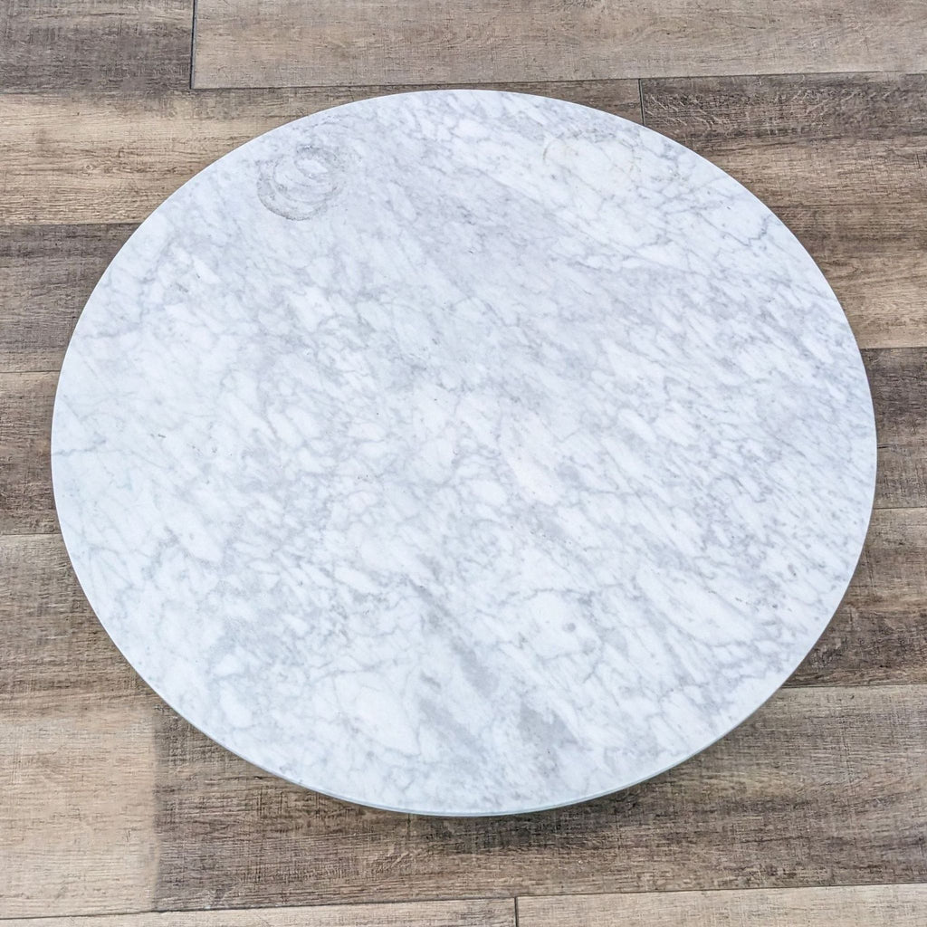 3. Top view of an Article coffee table showcasing its white marble surface and round shape, placed on a wooden floor.