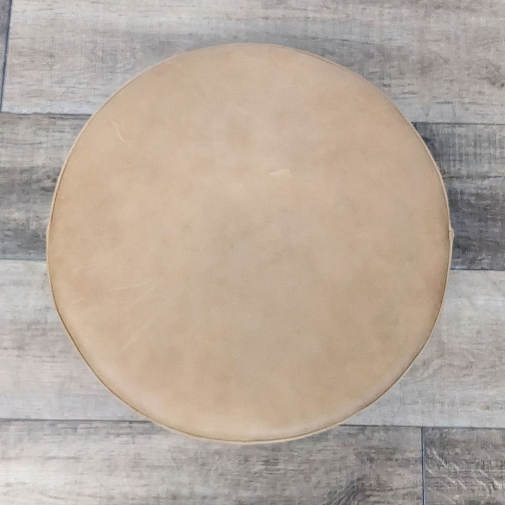 Top view of 16" round ottoman, tan leather finish.
