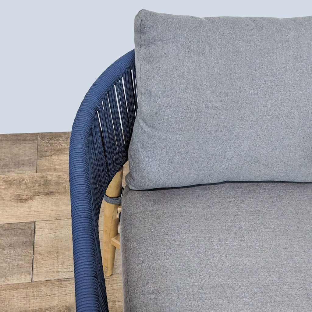 3. Close-up of the navy woven rope detail on an Article lounge chair with a solid acacia frame and soft gray cushions.