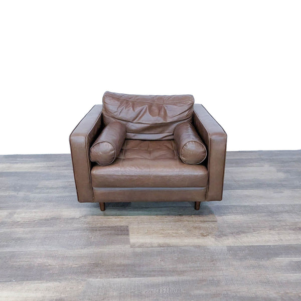 1. Front view of a modern Sven leather lounge chair by Article with tufted seat, stuffed back cushion, and two round bolsters.