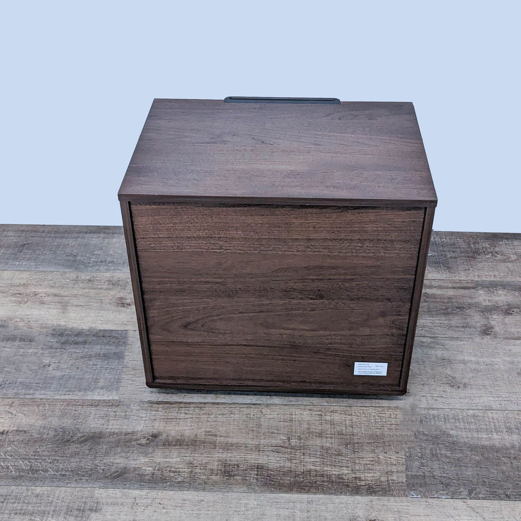 Article end table made of veneered wood with metal handle, front view, label visible on wood floor.