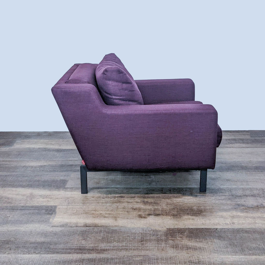 2. Side view of an EQ3 Plum fabric lounge chair showcasing the deep cushioning and solid mahogany wood legs.