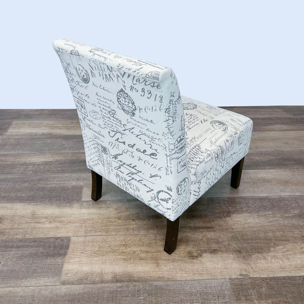 Rear perspective of CortesiHome Chicco accent chair showcasing script upholstery and black legs on laminate flooring.