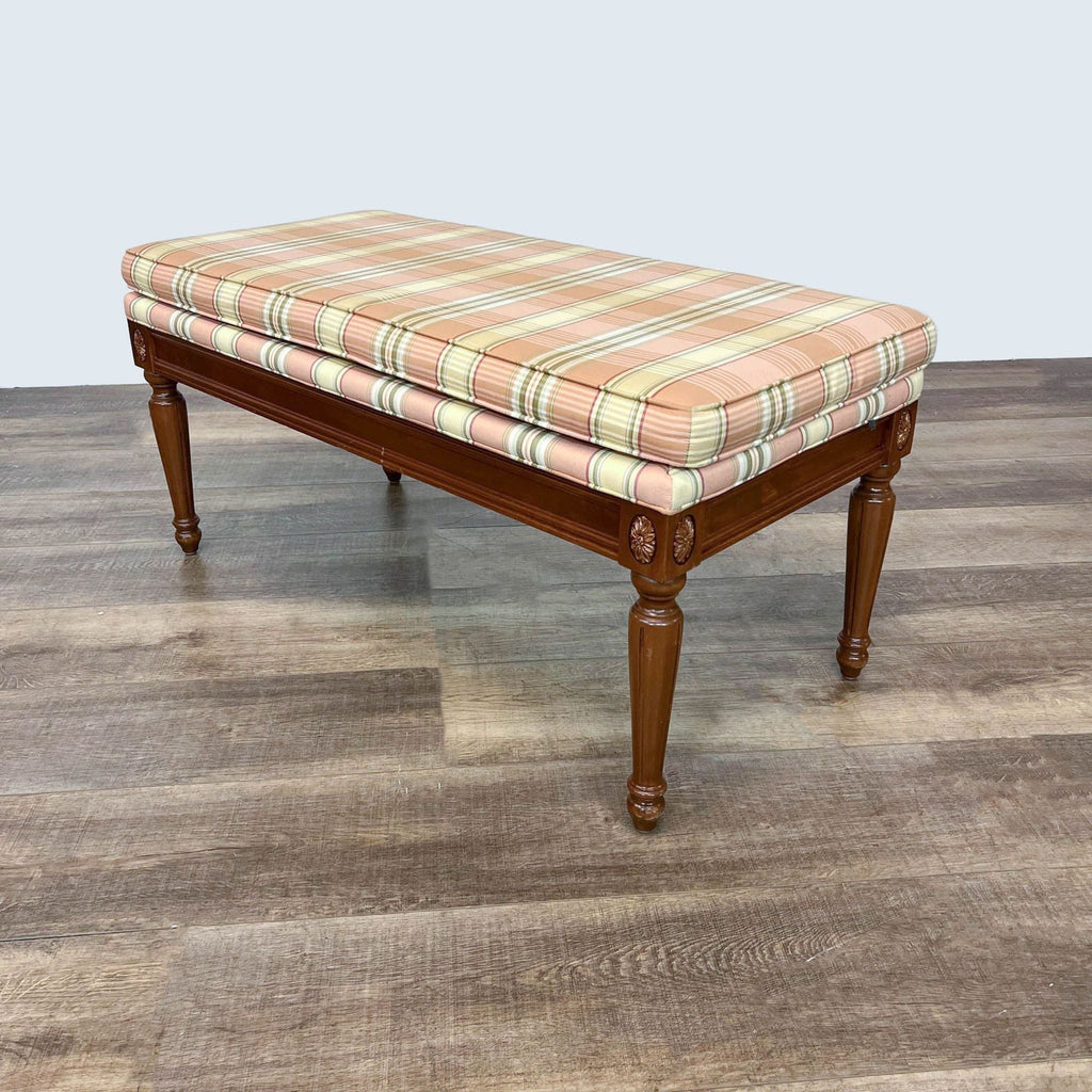 Solid wood bench with tan and green plaid fabric cushion by Ethan Allen, against a neutral background.