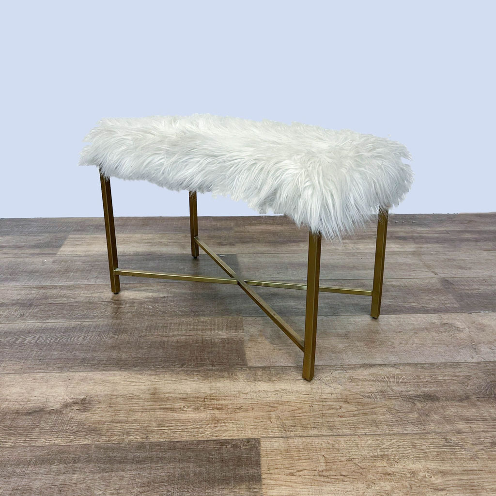 2. Front angle view of a 29" faux fur white bench by Reperch with a golden metal frame, on a wooden surface.