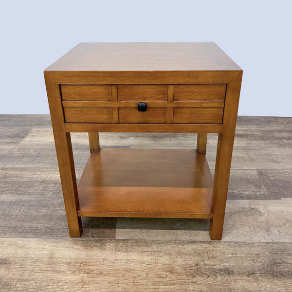 Crate & Barrel wood end table with drawer and lower shelf on a wooden floor.