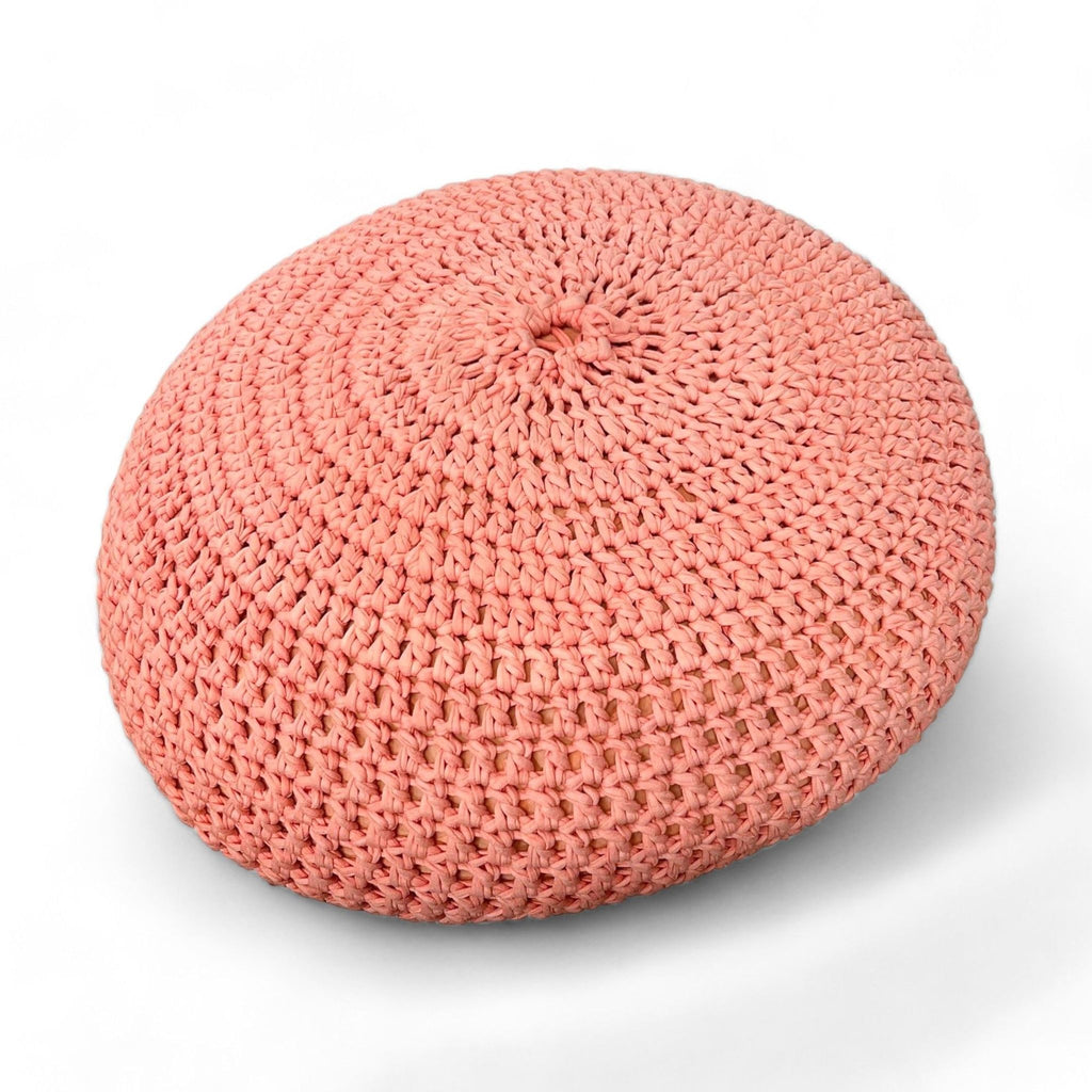2. Top view of a coral Reperch knitted pouf showing the intricate weave pattern.