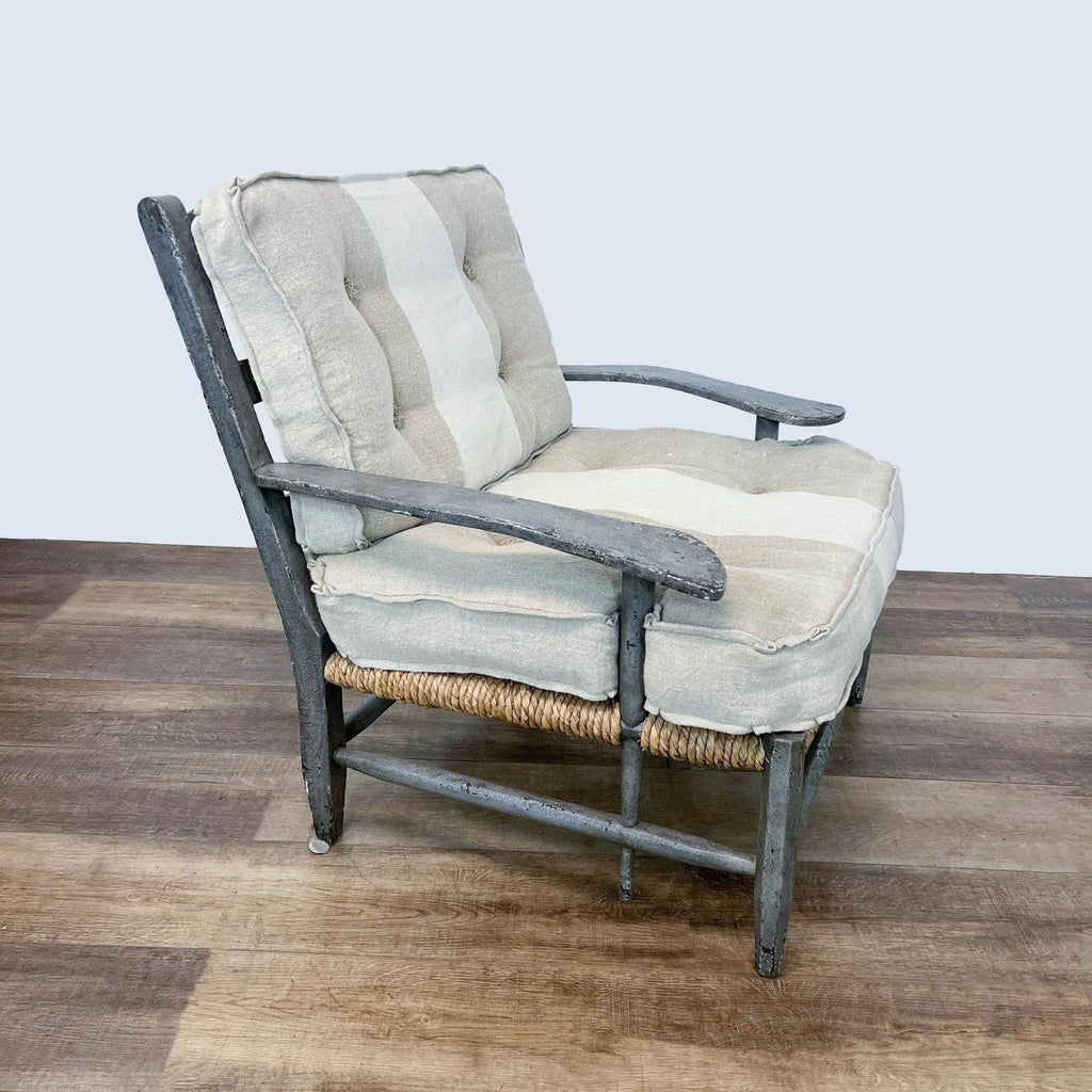 2. Side angle of a weathered wooden lounge chair by One King's Lane with a rattan seat and neutral linen cushions.