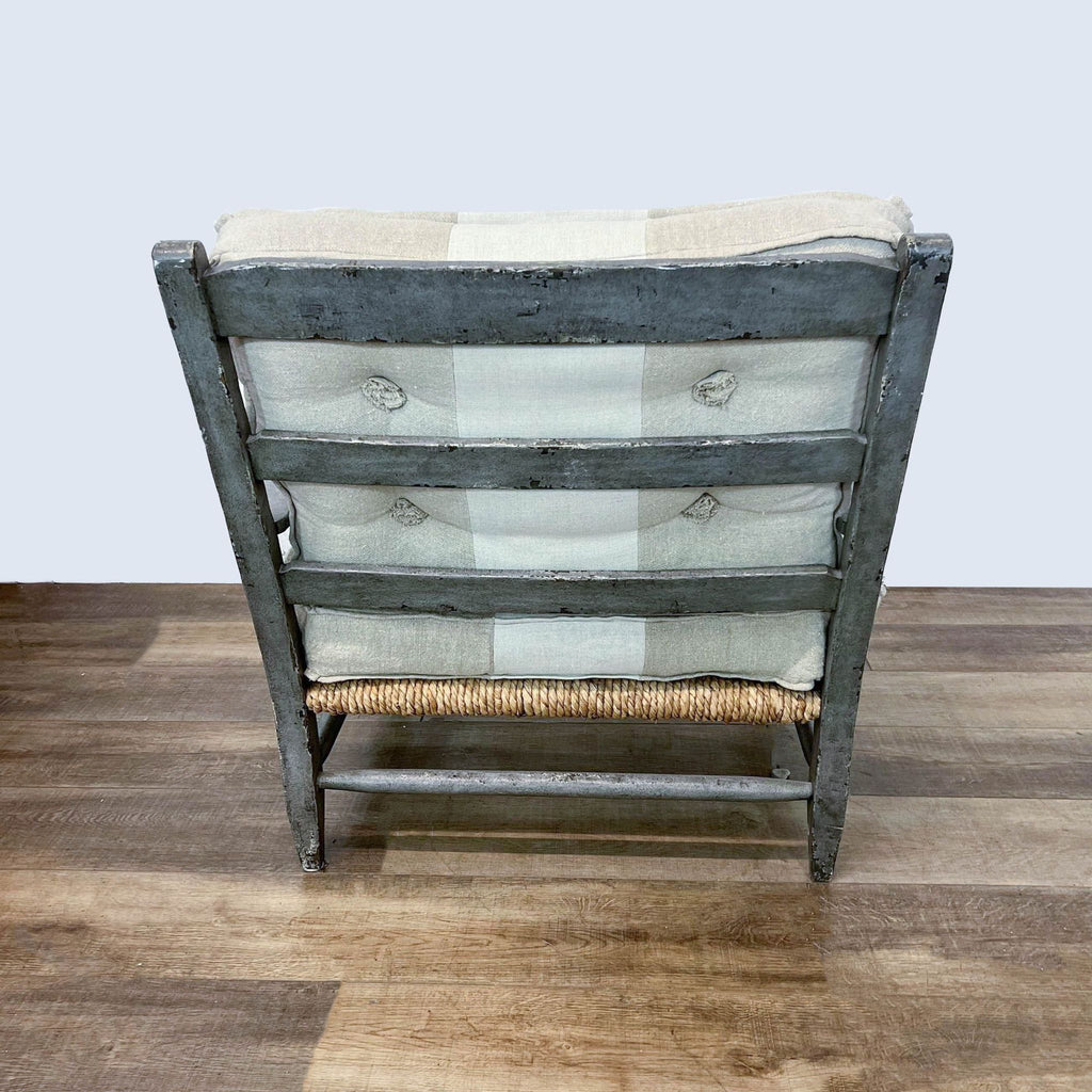 3. Rear view of a One King's Lane rustic lounge chair showcasing its button-tufted linen back and weathered wooden frame.