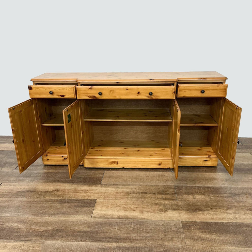 2. Open view of the Ducal pine sideboard with doors and drawers ajar, revealing inner shelves and storage space.