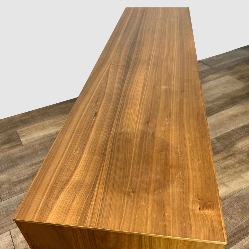 Top-down perspective on a walnut veneer Blu Dot entertainment center, highlighting the wood grain and finish on the surface.