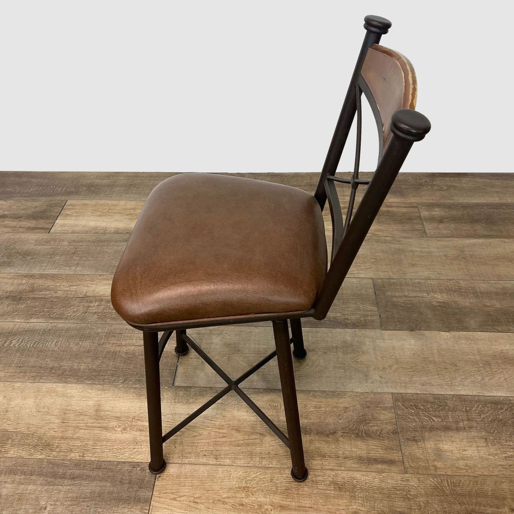 Brown leather-look seat on a metal stool with wood detailing and crisscross back by Reperch.
