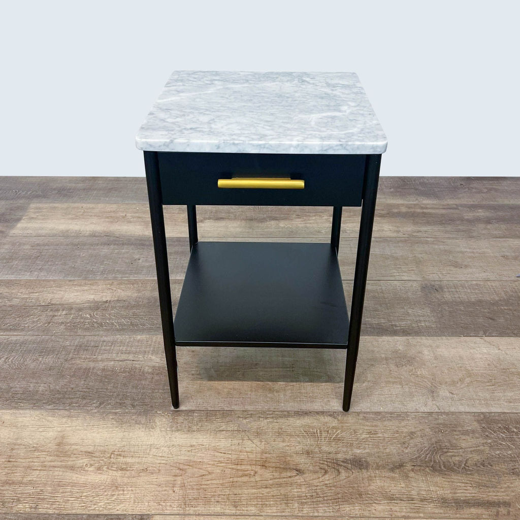 Modern end table with a marble top, black drawer, and gold handle by West Elm.