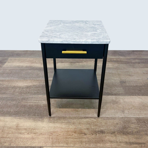 Modern end table with a marble top, black drawer, and gold handle by West Elm.