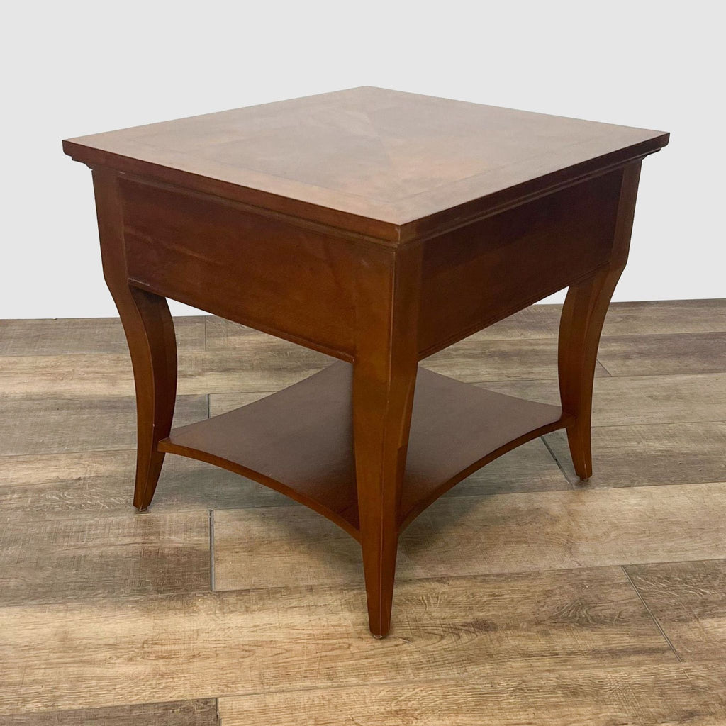 Diagonally positioned Thomasville wood end table featuring an inlaid top, cabriole legs, and shelf, on a laminate flooring background.