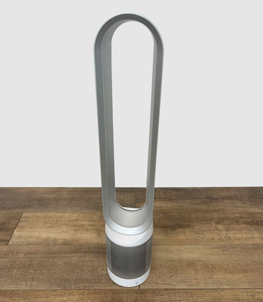 1. Sleek, silver Dyson bladeless fan on a wooden floor, emphasizing modern design and safety features.