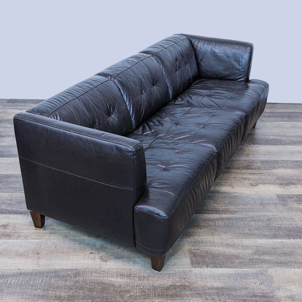 Angled side view of a brown Chateau d'Ax 3-seat sofa showcasing the plush design and wooden legs.