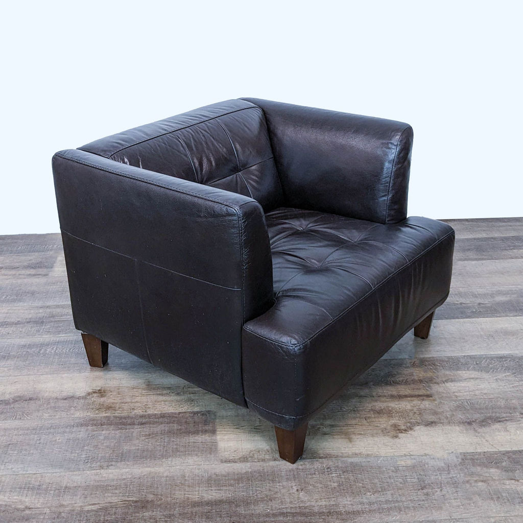 Chateau d'Ax leather armchair angled view highlighting the wide seat, tufted back, and sturdy wooden legs for a classic look.